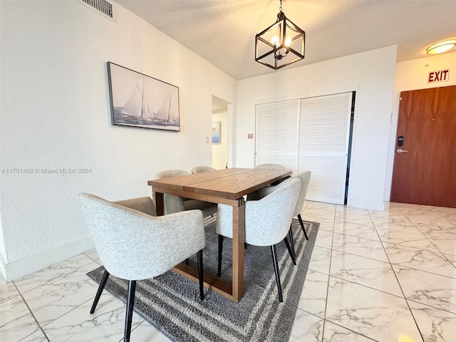 dining room with a chandelier and a textured ceiling