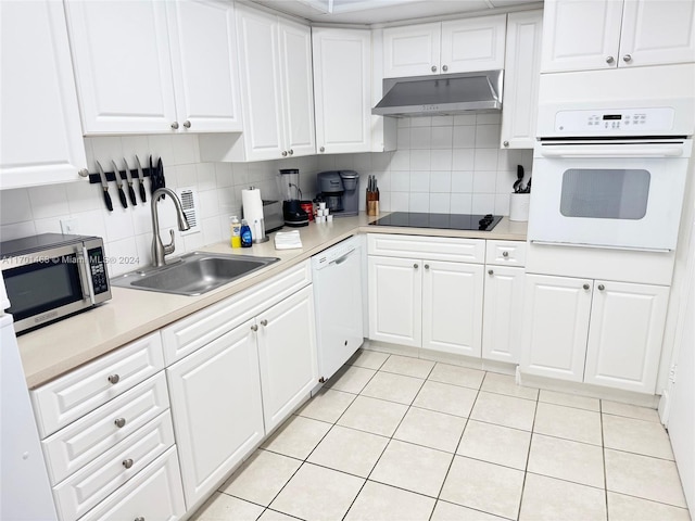 kitchen featuring white cabinetry, sink, white appliances, decorative backsplash, and light tile patterned flooring