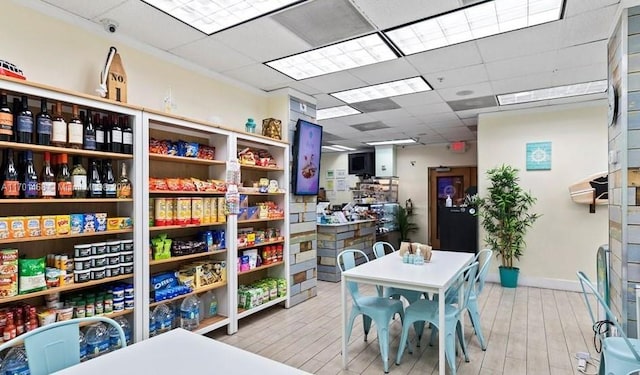 interior space featuring a paneled ceiling and light hardwood / wood-style floors