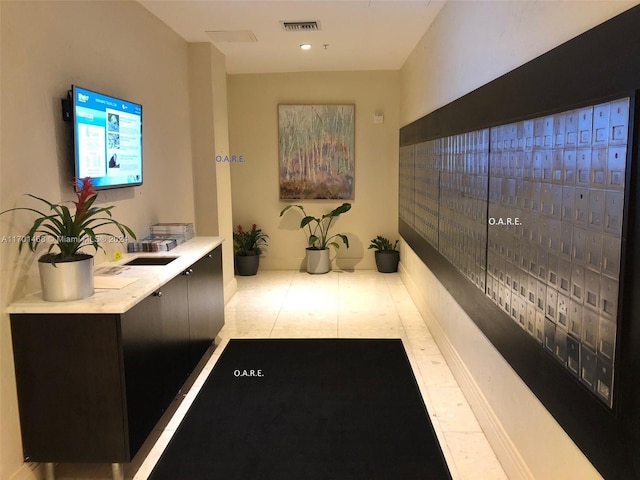 hall with light tile patterned floors and a mail area