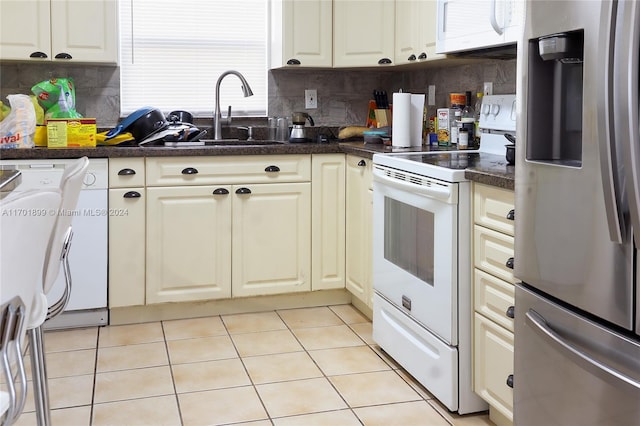 kitchen with white appliances, sink, decorative backsplash, light tile patterned floors, and washer / dryer