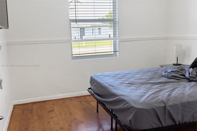 bedroom with hardwood / wood-style floors and multiple windows