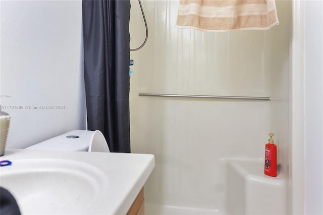 bathroom with a shower with curtain, sink, and toilet