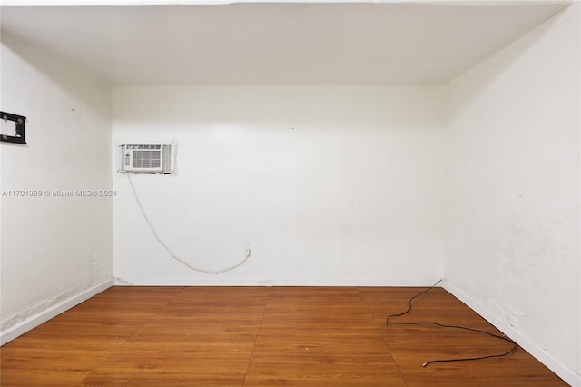 unfurnished room featuring hardwood / wood-style flooring and a wall mounted AC