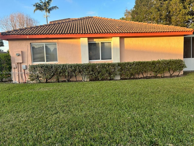 view of side of home with a lawn