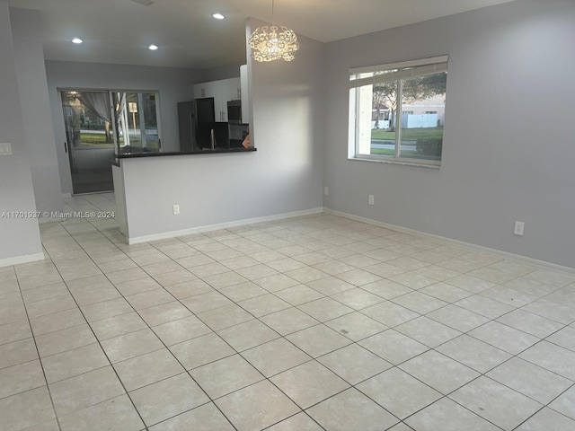 interior space with light tile patterned floors and an inviting chandelier