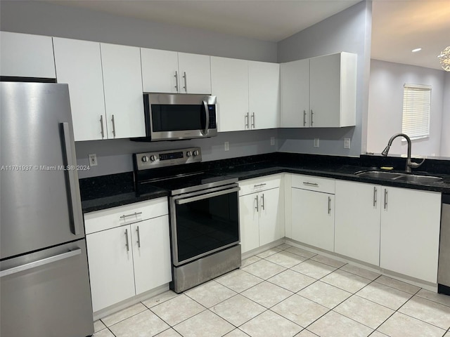 kitchen featuring dark stone countertops, sink, white cabinetry, and stainless steel appliances