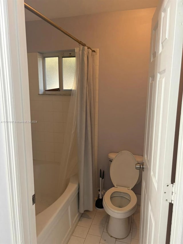 bathroom featuring tile patterned flooring, shower / bath combo, and toilet