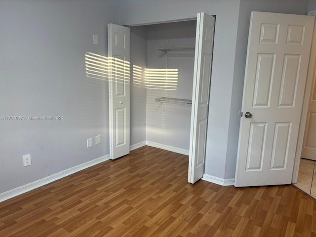 unfurnished bedroom with wood-type flooring and a closet