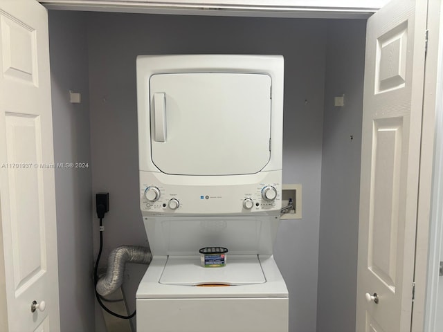 clothes washing area with stacked washer / dryer