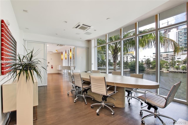 office area featuring dark hardwood / wood-style floors, expansive windows, and a water view