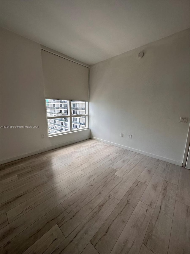 unfurnished room with light wood-type flooring