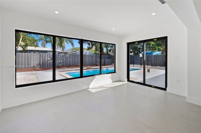 unfurnished room featuring concrete floors and a healthy amount of sunlight