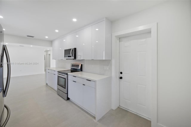 kitchen featuring white cabinets, decorative backsplash, and stainless steel appliances