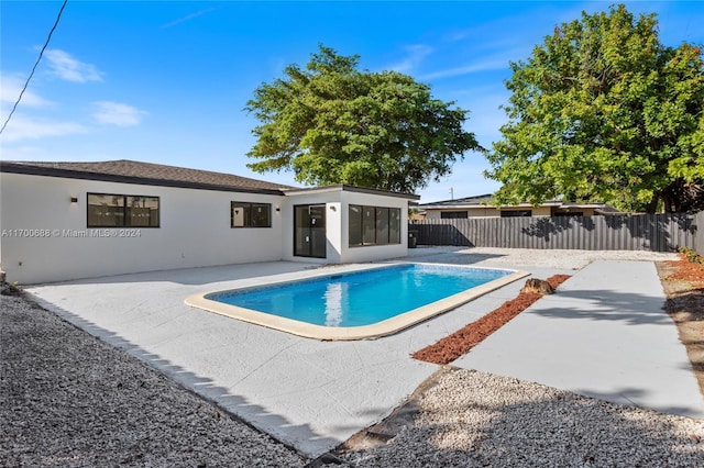 view of swimming pool with a patio area and a sunroom