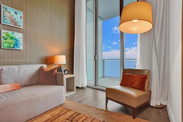 sitting room with a water view and wood-type flooring