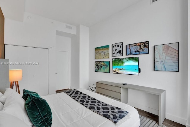 bedroom with wood-type flooring and a closet