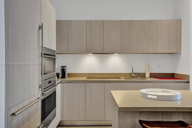 kitchen with appliances with stainless steel finishes, light brown cabinets, and sink