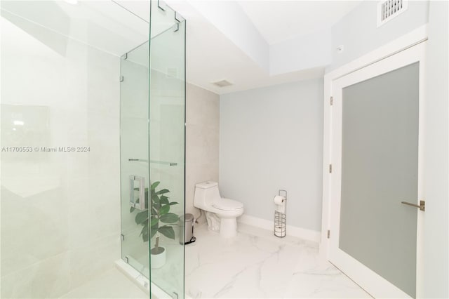 bathroom featuring an enclosed shower and toilet