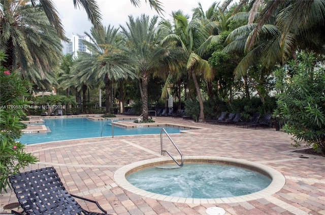 view of swimming pool with a patio area and a hot tub