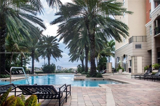 view of pool featuring pool water feature and a patio