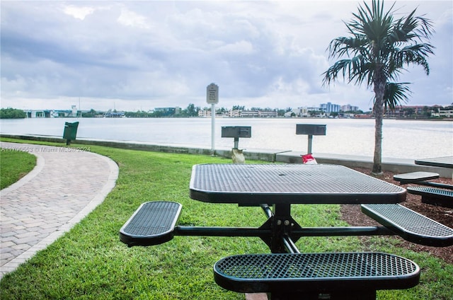 view of community featuring a lawn and a water view