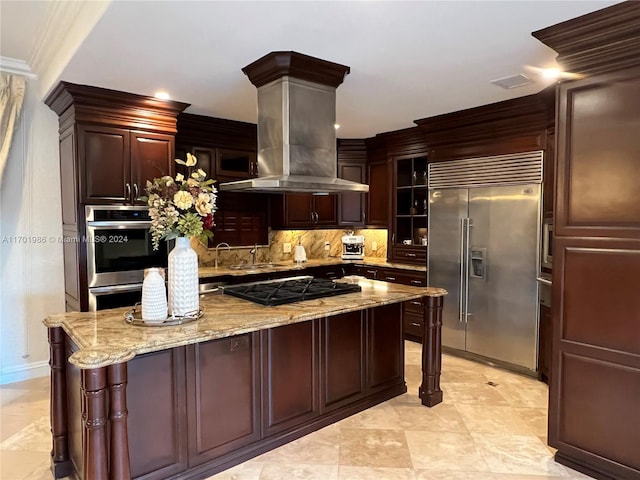 kitchen with island exhaust hood, tasteful backsplash, light stone counters, stainless steel appliances, and crown molding