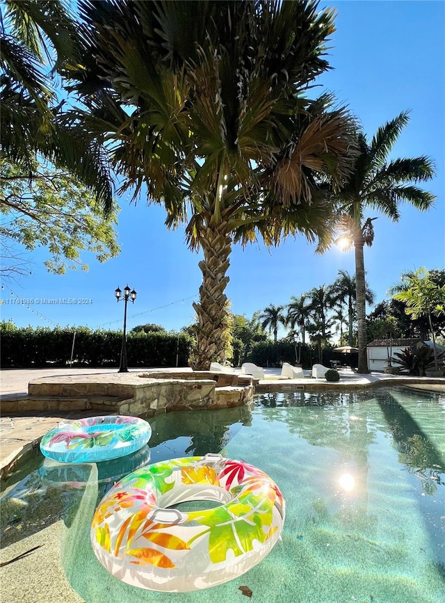 view of property's community featuring a swimming pool with hot tub