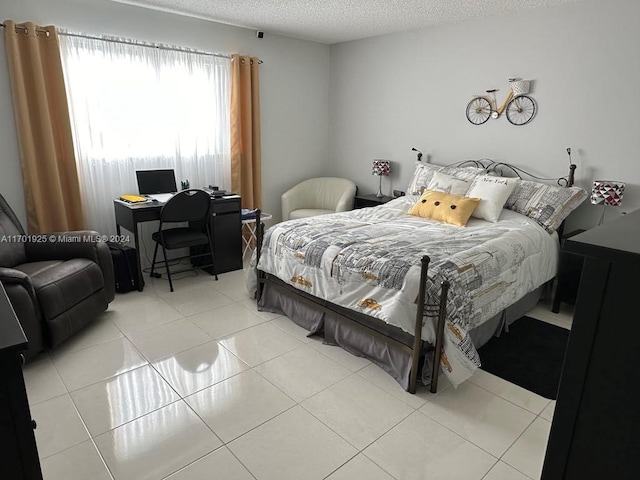 bedroom with light tile patterned floors and a textured ceiling