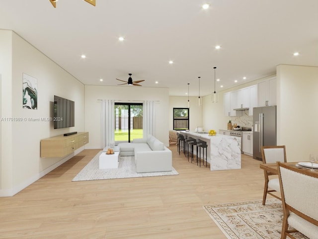 living room with ceiling fan, light hardwood / wood-style flooring, and sink