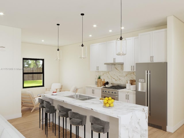 kitchen with white cabinetry, high quality appliances, and a center island with sink