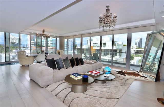 living room with a chandelier, light hardwood / wood-style flooring, and plenty of natural light