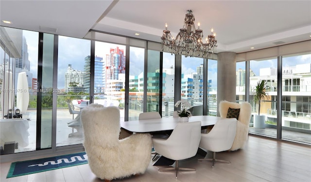 dining room featuring an inviting chandelier, expansive windows, and hardwood / wood-style flooring