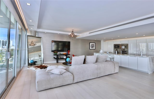 living room with a notable chandelier and light wood-type flooring