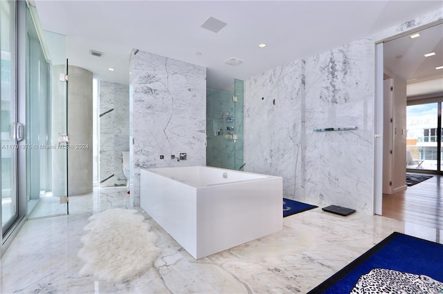 bathroom featuring separate shower and tub and tile walls