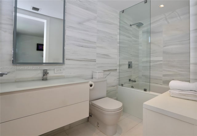 full bathroom with tile patterned flooring, vanity, toilet, and tile walls