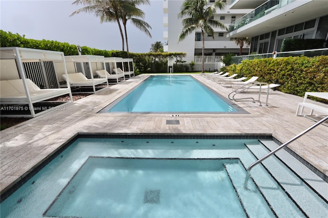 view of swimming pool with a patio area and a community hot tub