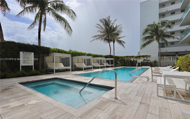 view of pool with a patio and a hot tub