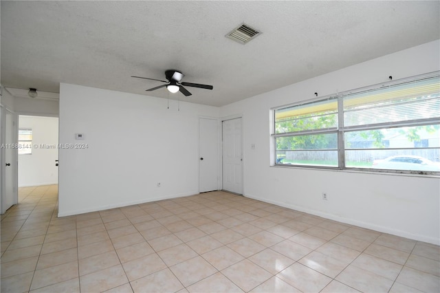 tiled spare room featuring ceiling fan and a textured ceiling