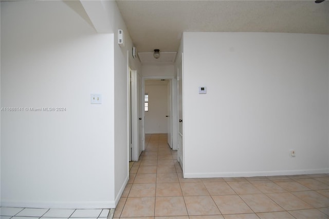 hallway featuring light tile patterned flooring and a textured ceiling