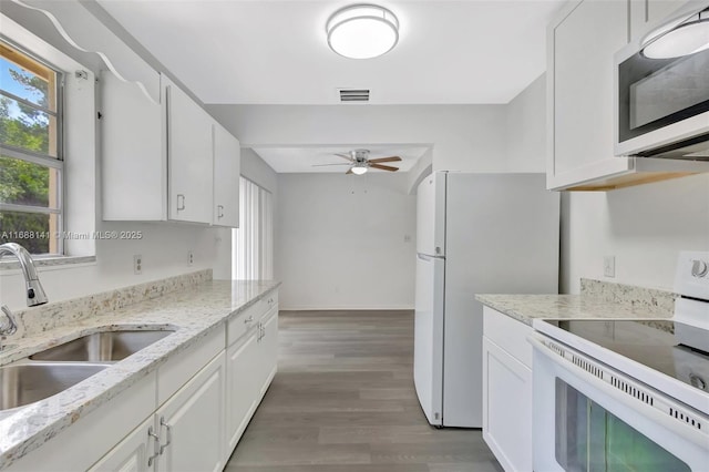 1101 SW Addie St, Port St Lucie, FL 34983 - kitchen featuring white appliances, a ceiling fan, light wood finished floors, and white cabinets