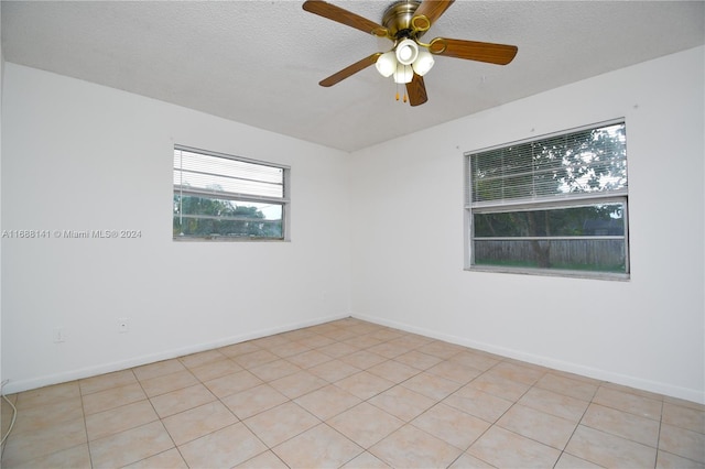 tiled spare room featuring ceiling fan and a textured ceiling