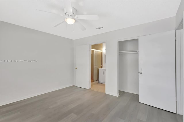 1101 SW Addie St, Port St Lucie, FL 34983 - unfurnished bedroom with wood finished floors, a closet, a ceiling fan, and connected bathroom