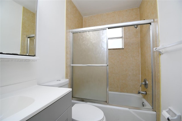 full bathroom with vanity, toilet, and bath / shower combo with glass door