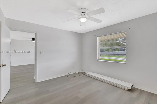 1101 SW Addie St, Port St Lucie, FL 34983 - unfurnished room featuring a ceiling fan, wood finished floors, and a baseboard heating unit
