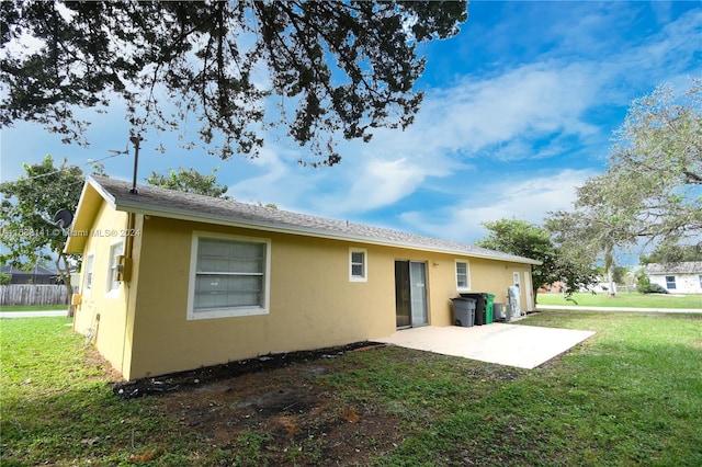 back of property with a patio area and a yard