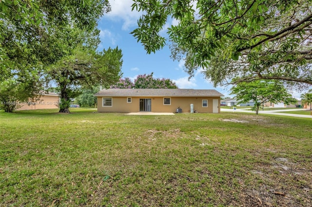 1101 SW Addie St, Port St Lucie, FL 34983 - rear view of house with stucco siding, a patio area, and a yard