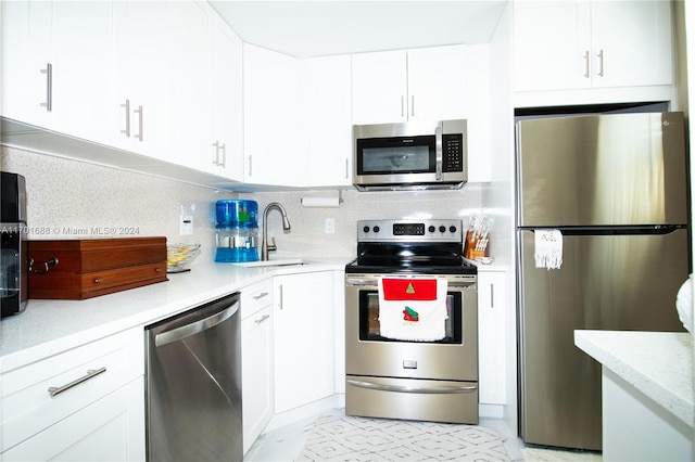 kitchen with decorative backsplash, white cabinetry, sink, and appliances with stainless steel finishes