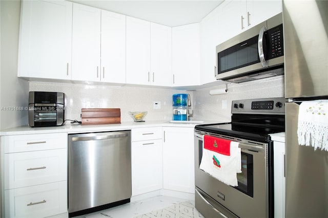 kitchen featuring appliances with stainless steel finishes, backsplash, and white cabinetry