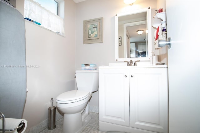 bathroom with tile patterned flooring, vanity, and toilet